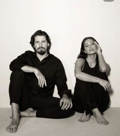 a man and woman sitting on the floor next to each other