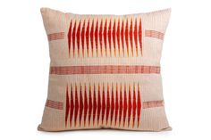 a red and white pillow on a white background