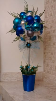 a blue vase filled with ornaments on top of a counter