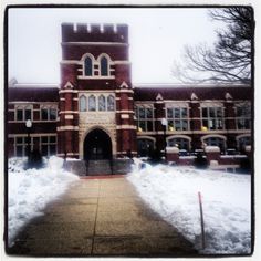 an old brick building with snow on the ground