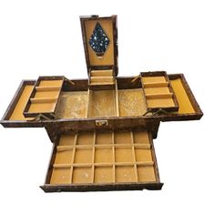 an open wooden box with compartments on the top and bottom, filled with small objects