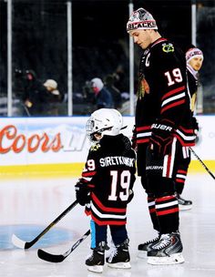 an ice hockey player and his son on the ice