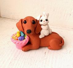 a dog and cat figurine sitting next to each other with an easter basket