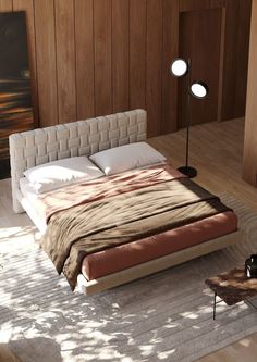 a large bed sitting on top of a wooden floor next to a table and chair