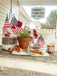 an american flag potted in front of a country fresh eggs for sale sign