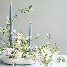 some blue candles and flowers on a table