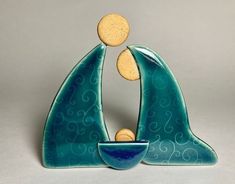 a ceramic figurine with a bowl in the shape of a sailboat and two corks