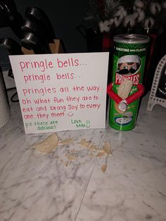 a sign that is on the counter next to a can of pringle bells