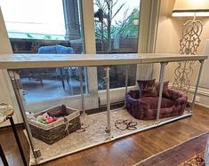 a dog bed in the middle of a living room next to a large glass window