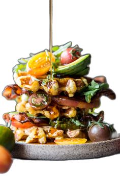 a stack of food that is sitting on top of a metal tray with fruit and vegetables