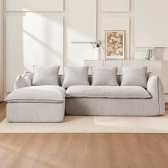 a large gray couch sitting on top of a hard wood floor