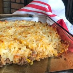 a casserole dish with cheese and meat in it sitting on a table next to a napkin