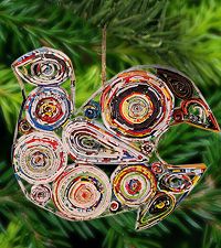 a colorful bird ornament hanging from a christmas tree with pine needles in the background