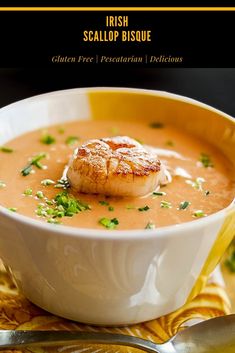 a bowl filled with soup and topped with scallop