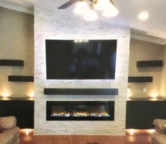 a living room with two couches and a flat screen tv mounted on the wall