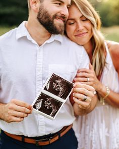 a man and woman smile as they hold an old photo