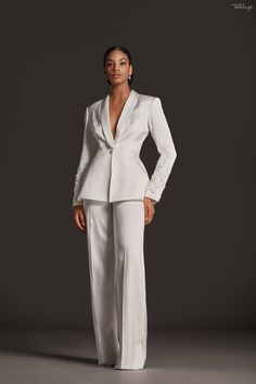 a woman in a white suit posing for the camera