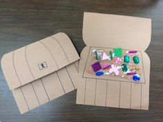 an open cardboard box with different colored stones on it and a paper bag next to it