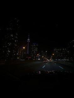 the city lights shine brightly at night from inside a vehicle's dashboard, as it drives through an empty street