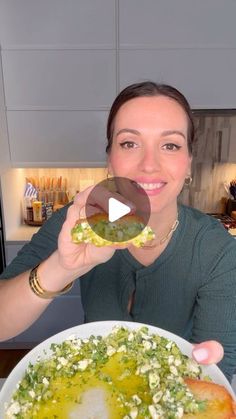 a woman is holding up a plate of food