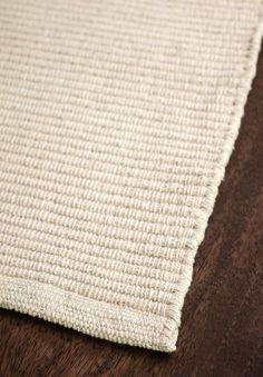 a close up view of a white rug on a wooden floor