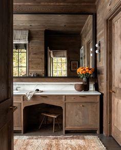 a bathroom with wooden walls and a large mirror