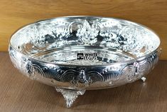 a silver bowl sitting on top of a wooden table