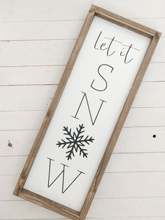 a wooden sign that says let it snow with a snowflake on the bottom