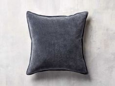 a gray pillow on a white wall