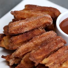 some fried food on a white plate with dipping sauce