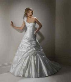 a woman in a white wedding dress standing against a wall