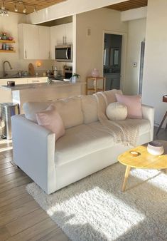 a living room filled with furniture next to a kitchen