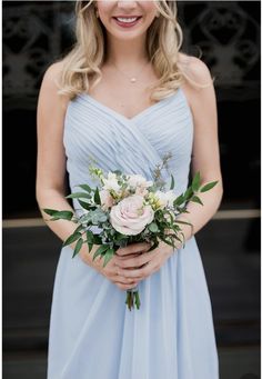 a woman in a blue dress holding a bouquet