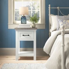 a bedroom with blue walls and white furniture