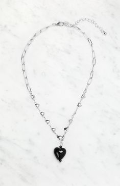 The LA Hearts Black Heart Chain Necklace is a sleek and versatile piece, perfect for adding a touch of edge to any outfit. The silver hearts and black drop charm create a chic contrast, while the adjustable closure ensures a comfortable fit for all.


	Chain link design
	Silver heart accents
	Black drop charm
	Adjustable lobster clasp closure Black Metal Heart Necklace For Valentine's Day, Black Metal Heart Necklace With Adjustable Chain, Black Metal Necklace With Heart Charm, Trendy Black Metal Heart Necklace, Black Heart Beads Necklace For Valentine's Day, Black Double Heart Necklace For Valentine's Day, Black Chain Necklace For Valentine's Day, Black Stainless Steel Necklace For Valentine's Day, Black Stainless Steel Heart Pendant Necklace