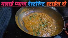 a pan filled with food on top of a stove next to carrots and spices