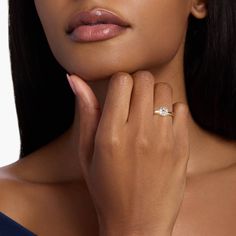 a woman wearing a diamond ring with her hand near her face