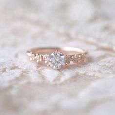 a close up of a diamond ring on a white surface