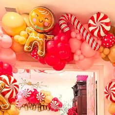 balloon decorations and balloons are hanging from the ceiling above a mirror in a pink room