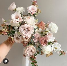 a white vase filled with lots of pink and white flowers