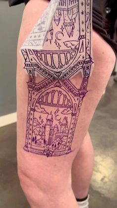 a woman's thigh with purple ink on it and an image of a building