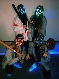 four people in costumes with neon masks and baseball bats