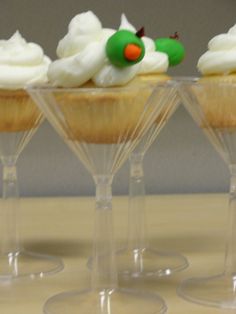 four wine glasses filled with cupcakes on top of a table