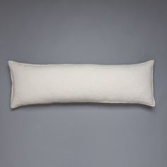 a white pillow sitting on top of a gray wall