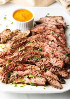 a plate with steak and dipping sauce on it