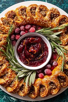 a white plate topped with cranberry sauce and pretzels covered in rosemary