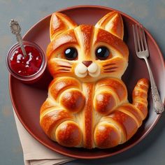 an orange plate with a cat shaped pastry on it