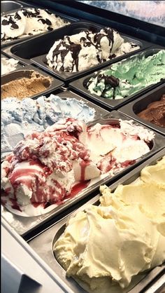 an assortment of ice creams in trays with different colors and flavors on them