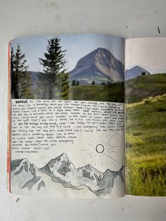 an open book with pictures of mountains and trees in the pages, on top of a table