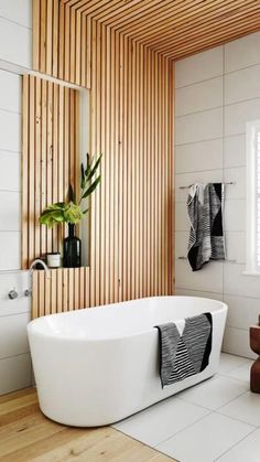 a white bath tub sitting in a bathroom next to a window